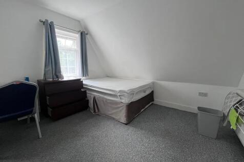 A cozy single bedroom featuring a comfortable b...