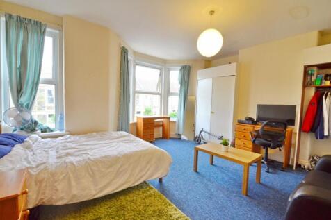 This cozy double bedroom features ample natural...