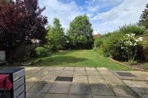 A spacious and well-maintained garden with a la...