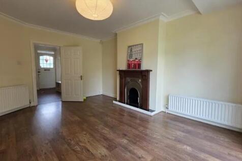 Bright living room with warm wooden floors, a c...