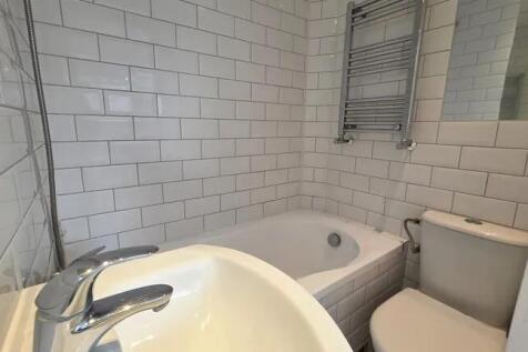Bright and modern bathroom suite featuring a cl...