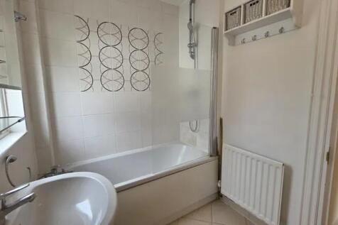 Bright and clean bathroom suite featuring a mod...