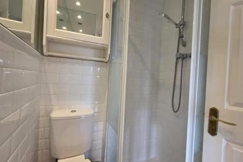 A clean, modern bathroom featuring white tiled ...
