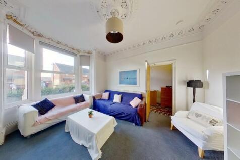 Bright and airy living room featuring large win...