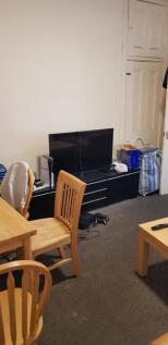 A cozy living room featuring a TV on a black st...