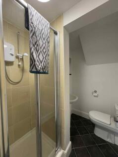 A modern bathroom featuring a shower unit with ...