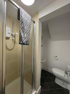 A clean, well-maintained bathroom with a shower...