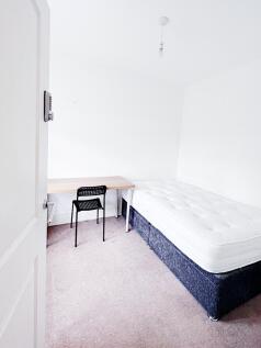 Bright, simply furnished bedroom with a comfort...