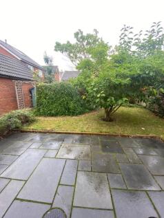 Private rear garden with paved patio leading to...