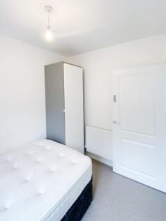 Bright, freshly painted single bedroom with a c...