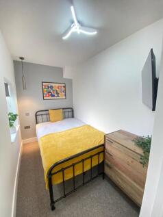 Cozy double bedroom featuring a vibrant yellow ...