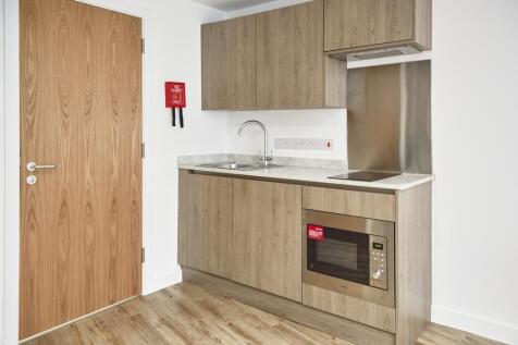 A modern kitchenette with clean finishes, perfe...