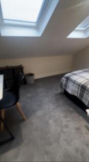 This spacious double bedroom features a cozy at...