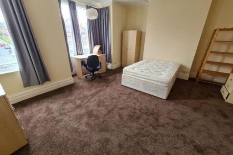 A modest single bedroom featuring a mattress, a...