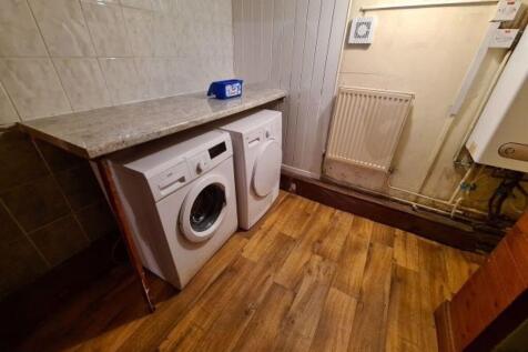 A functional laundry area featuring a washing m...