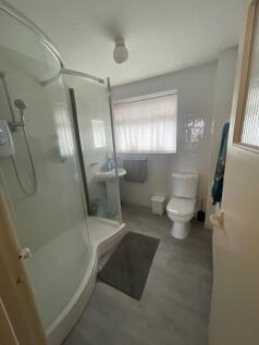 A clean and modern bathroom featuring a curved ...
