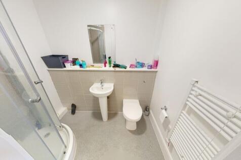 This modern bathroom features a spacious shower...