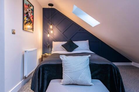 This stylish double bedroom features a cozy lay...