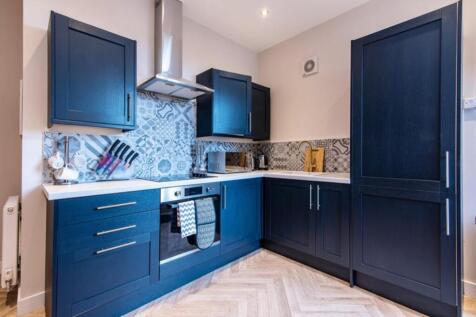 This stylish kitchen features modern cabinetry ...