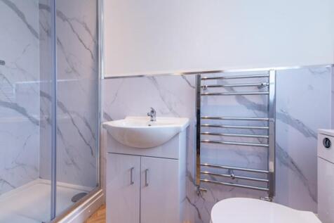 A modern bathroom featuring sleek marble walls,...