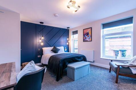 A stylish and spacious master bedroom featuring...