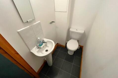 A tidy and functional single toilet with modern...