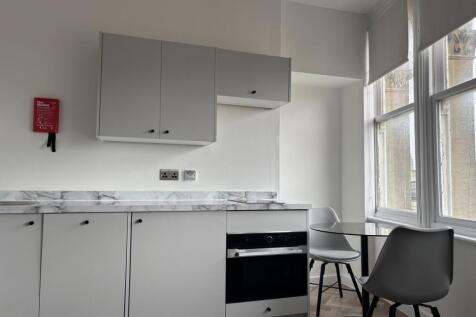 A modern and clean kitchenette with ample natur...