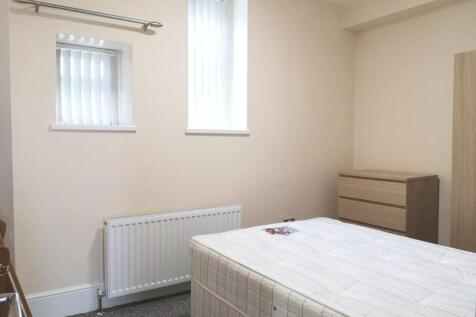A neat and simple bedroom featuring a comfortab...
