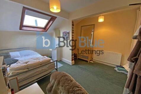 A bright double bedroom featuring a comfortable...