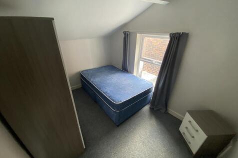 This cozy double bedroom features ample natural...
