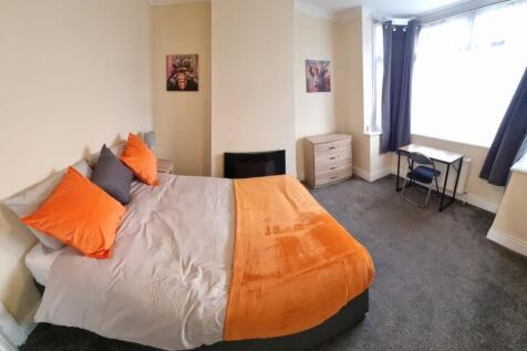A stylish double bedroom featuring a cozy orang...