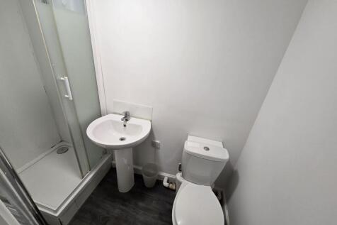 A modern bathroom featuring a shower, sink, and...