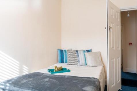 A cozy double bedroom featuring large windows t...