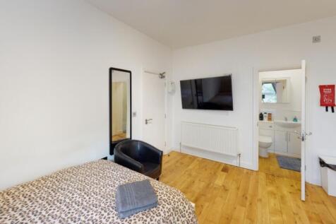 A cozy double bedroom featuring a stylish bed w...