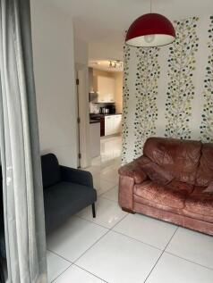 A bright and contemporary living room featuring...