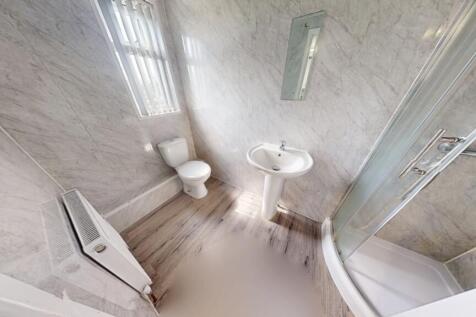 A modern bathroom suite featuring a spacious sh...