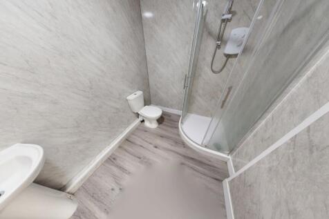 Compact bathroom featuring a modern corner show...