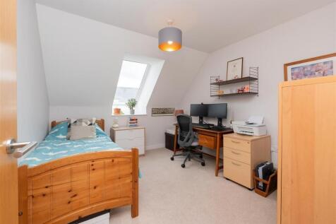 A bright and tidy single bedroom featuring a wo...