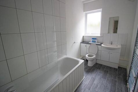 A spacious bathroom featuring a sleek bathtub a...