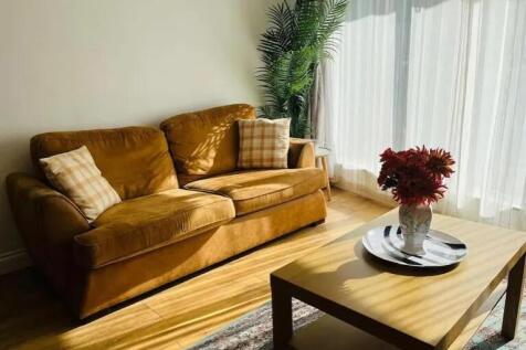 A cozy living room featuring a warm mustard-col...