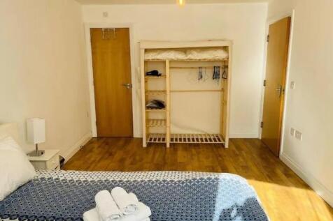 Bright and tidy double bedroom featuring wooden...