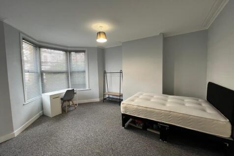 A spacious and bright double bedroom featuring ...