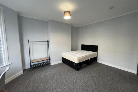 A spacious and well-lit double bedroom, perfect...