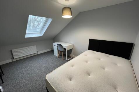 A spacious and inviting double bedroom with a m...