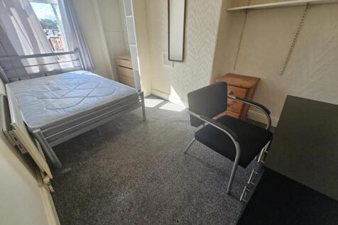 A well-lit bedroom featuring a double bed and a...