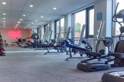 A spacious and well-equipped gym with large win...