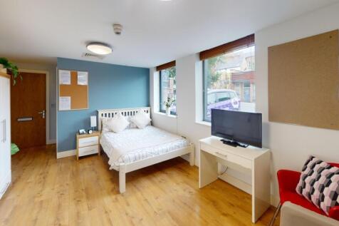 A spacious and bright bedroom featuring a comfo...