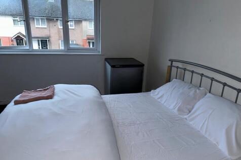 A bright double bedroom featuring a neatly made...