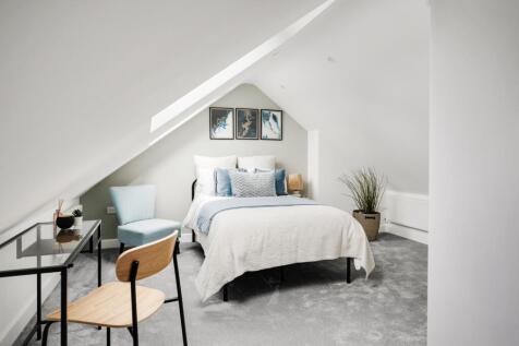 A bright and inviting double bedroom with styli...