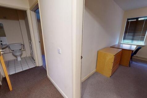 A clean and tidy small toilet adjacent to a com...